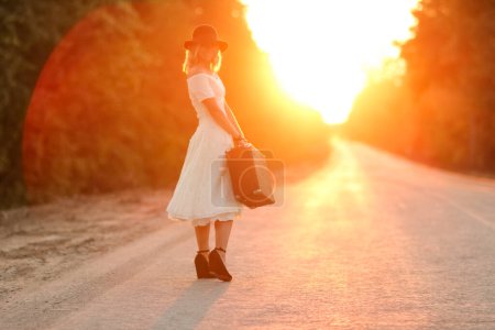 Téléchargez les photos : Vintage fille avec chapeau avec une valise auto-stop - en image libre de droit