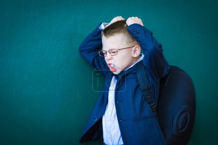 Foto de Niño feliz de pie en la pizarra con una mochila escolar con gafas - Imagen libre de derechos