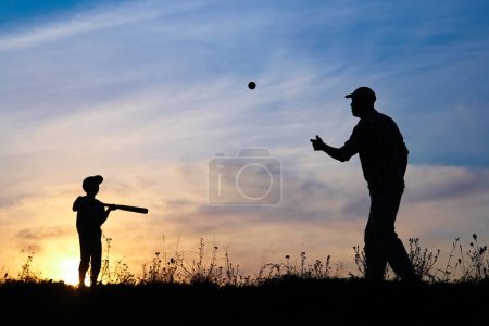 Foto de Niño feliz con los padres jugando béisbol concepto en el parque en la naturaleza - Imagen libre de derechos