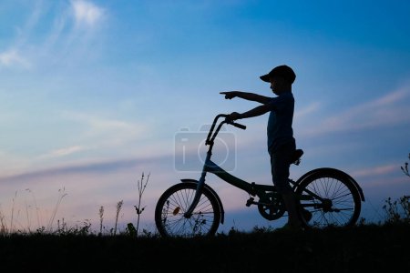Photo for Happy child and bike concept in park outdoors silhouette - Royalty Free Image