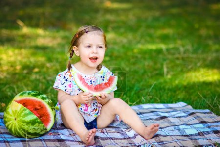 Téléchargez les photos : Enfant heureux avec pastèque sur la nature dans le parc - en image libre de droit