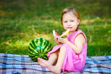 Téléchargez les photos : Enfant heureux avec pastèque sur la nature dans le parc - en image libre de droit