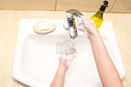 Photo for Hands with soap are washed under the tap with water. Clean from infection and dirt and virus. At home or in the hospital ablution office. - Royalty Free Image