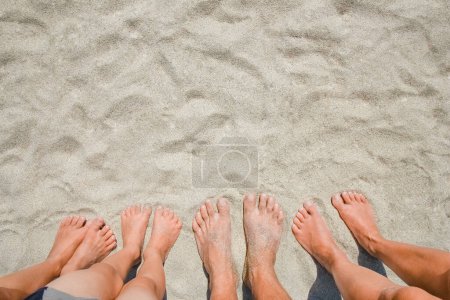 Téléchargez les photos : Pieds sur le sable des gens heureux au bord de la mer sur la nature Voyage - en image libre de droit