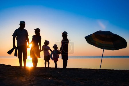 Photo for Happy family by the sea at sunset in travel silhouette in nature - Royalty Free Image