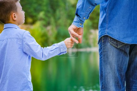 Téléchargez les photos : Les mains du parent et de l'enfant dans la nature dans le parc - en image libre de droit
