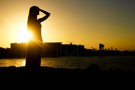 Photo for Happy girl near the sea silhouette in the nature - Royalty Free Image