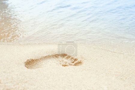 Téléchargez les photos : Voyage à la plage - femme relaxante marchant sur une plage de sable laissant des empreintes de pas dans le sable. Détail rapproché des pieds féminins sur du sable doré sur une plage en Grèce. Contexte. - en image libre de droit