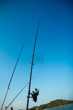 Photo for Fishing rods of a happy fisherman near the sea in nature on a journey background - Royalty Free Image