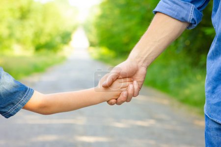 Photo for Hands of a happy parent and child in nature in the travel park - Royalty Free Image