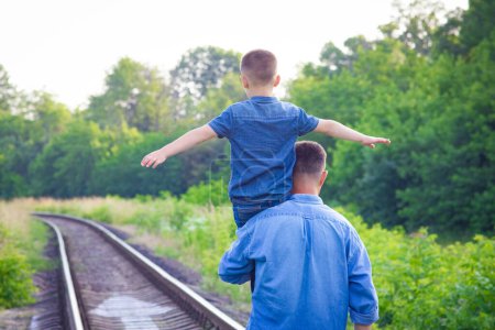 Photo for Happy child on the shoulders of a parent in nature on the way to travel - Royalty Free Image