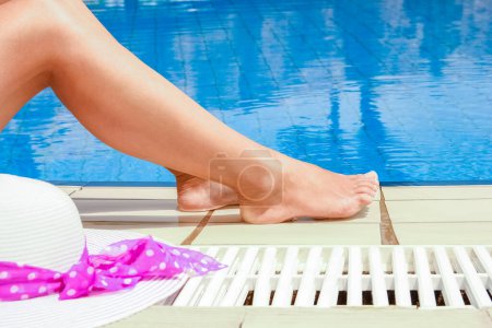 Photo for Beautiful legs of a girl near a swimming pool on the sea background - Royalty Free Image