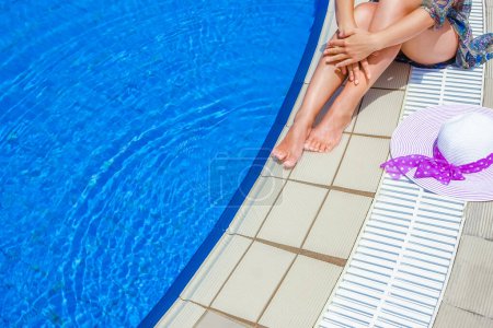 Téléchargez les photos : Belles jambes d'une fille près d'une piscine sur le fond de la mer - en image libre de droit
