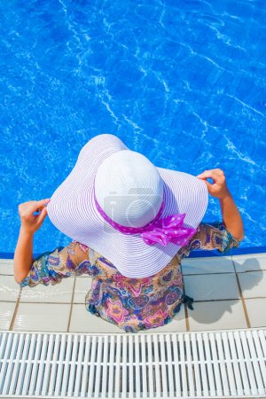 Photo for Beautiful legs of a girl near a swimming pool on the sea background - Royalty Free Image