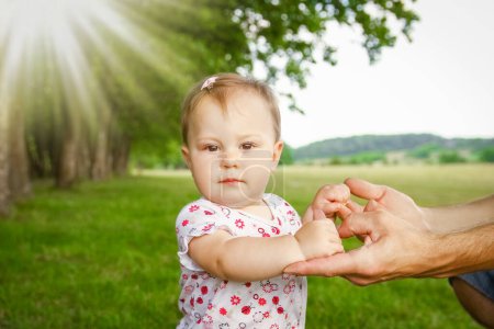 Téléchargez les photos : Mains d'un parent heureux et d'un enfant dans la nature - en image libre de droit