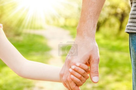Foto de El padre sosteniendo la mano del niño con un fondo feliz - Imagen libre de derechos