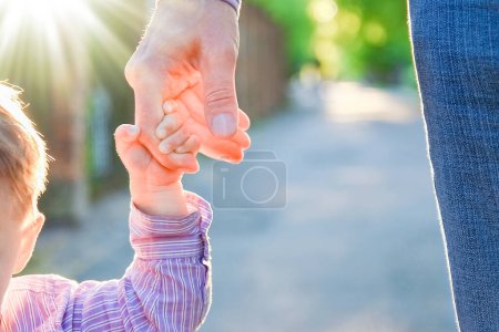 Foto de El padre sosteniendo la mano del niño con un fondo feliz - Imagen libre de derechos
