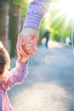 Téléchargez les photos : Le parent tenant la main de l'enfant avec un fond heureux - en image libre de droit