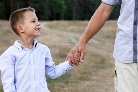 Téléchargez les photos : Heureux enfant et parent mains sur la nature dans le parc Voyage - en image libre de droit