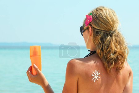 Téléchargez les photos : Fille heureuse sur la mer avec une photo du soleil sur le dos - en image libre de droit