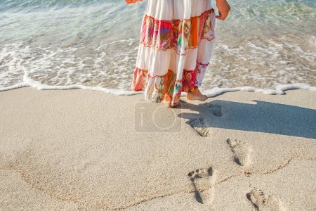 Téléchargez les photos : Belles empreintes de pas avec pieds sur le fond de sable - en image libre de droit