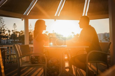 Photo for Happy couple at a table by the sea at sunset nature - Royalty Free Image