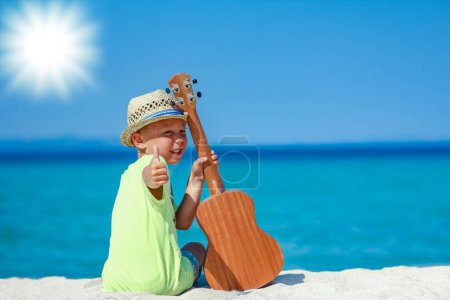 Téléchargez les photos : Enfant heureux avec ukulele à iorya dans la nature week-end Voyage - en image libre de droit