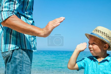 Foto de Manos de un padre feliz y un niño junto al mar en viaje por la naturaleza - Imagen libre de derechos