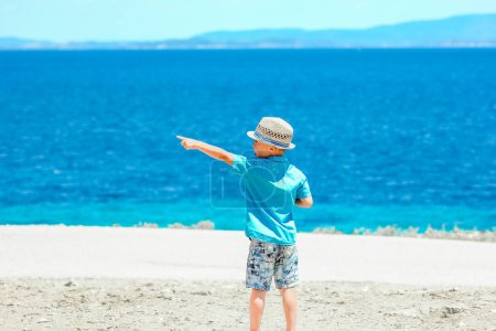 Téléchargez les photos : Enfant heureux près de la mer dans la nature lors d'un week-end - en image libre de droit