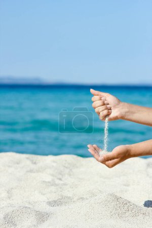 Téléchargez les photos : Mains versant du sable près du bord de la mer le week-end Voyage nature - en image libre de droit