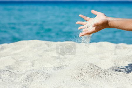 Photo for Hands pouring sand near the seashore on weekend nature travel - Royalty Free Image