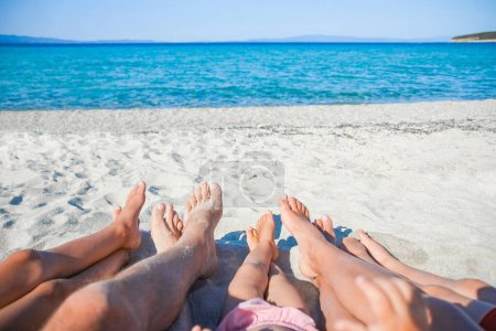 Téléchargez les photos : Pieds d'une famille heureuse près du bord de mer dans la nature week-end Voyage - en image libre de droit