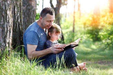 Téléchargez les photos : Père et enfant lisant la Bible concept famille - en image libre de droit