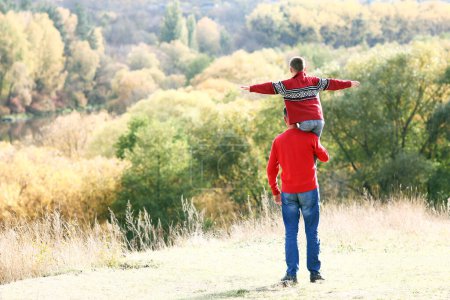 Photo for Father and son walking in the park in autumn concept family support happy - Royalty Free Image