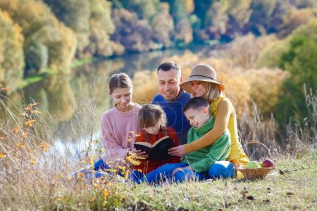 Téléchargez les photos : Heureux Famille lecture du livre Bible dans la nature concept famille - en image libre de droit