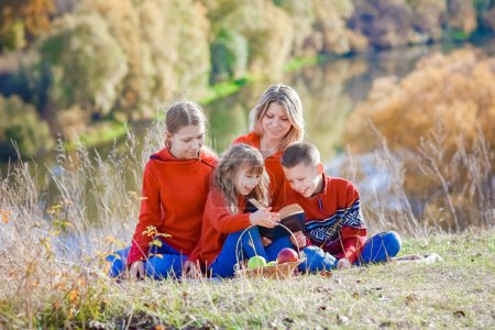 Téléchargez les photos : Heureux Famille lecture du livre Bible dans la nature concept famille - en image libre de droit