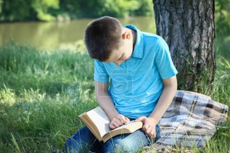 Photo for Child boy  read holy bible in park - Royalty Free Image