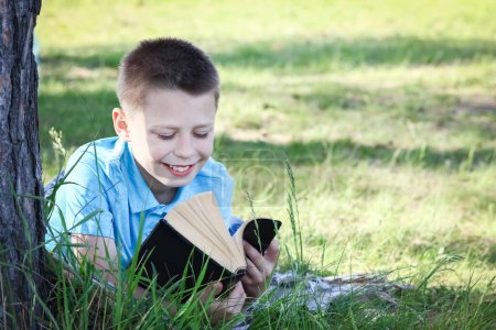 Téléchargez les photos : Enfant garçon lire sainte bible dans le parc - en image libre de droit