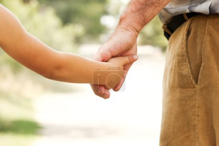 Téléchargez les photos : Le vieux parent tient la main d'un petit enfant concept famille - en image libre de droit
