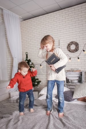 Téléchargez les photos : Enfant heureux lisant un livre à Noël - en image libre de droit