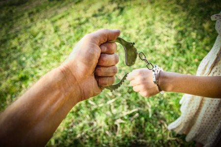 Photo for Man handcuffed outdoors in the park - Royalty Free Image