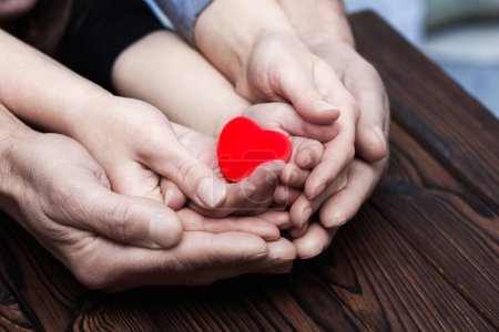 Téléchargez les photos : Heart in hands on valentine's day on a wooden background holiday - en image libre de droit
