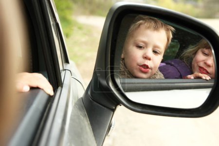 Foto de Niños felices emociones desde la ventana del coche - Imagen libre de derechos