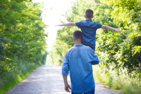 Téléchargez les photos : Happy child on the shoulders of a parent in nature on the way to travel - en image libre de droit
