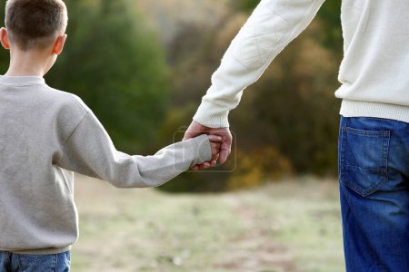 Téléchargez les photos : Heureux père tenant la main de l'enfant concept relations de soutien familial - en image libre de droit