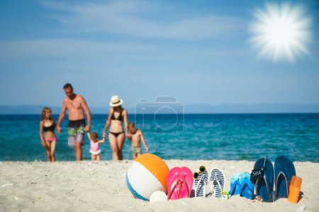 Téléchargez les photos : Famille heureuse sur la mer avec des pantoufles sur fond de nature - en image libre de droit