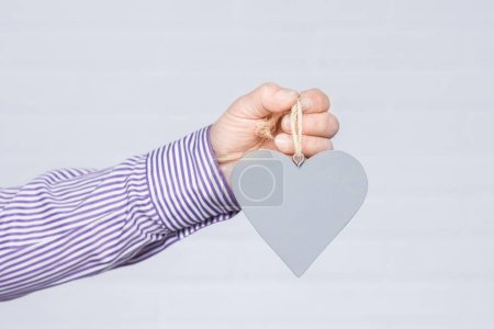 Foto de Heart in human hands on white brick background - Imagen libre de derechos