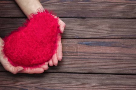 Téléchargez les photos : Heart in hands on valentine's day on a wooden background holiday - en image libre de droit