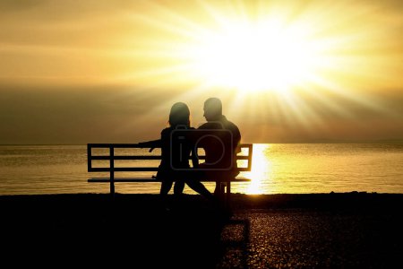Photo for Happy couple on a bench by the sea on nature in travel silhouette - Royalty Free Image