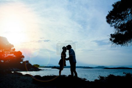 Foto de Feliz pareja por el mar en la naturaleza en silueta de viaje - Imagen libre de derechos